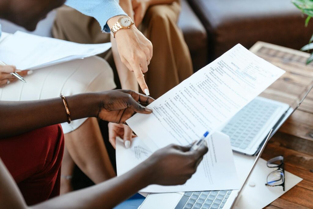 Group of professionals reviewing documents during an office meeting, emphasizing teamwork and strategy.