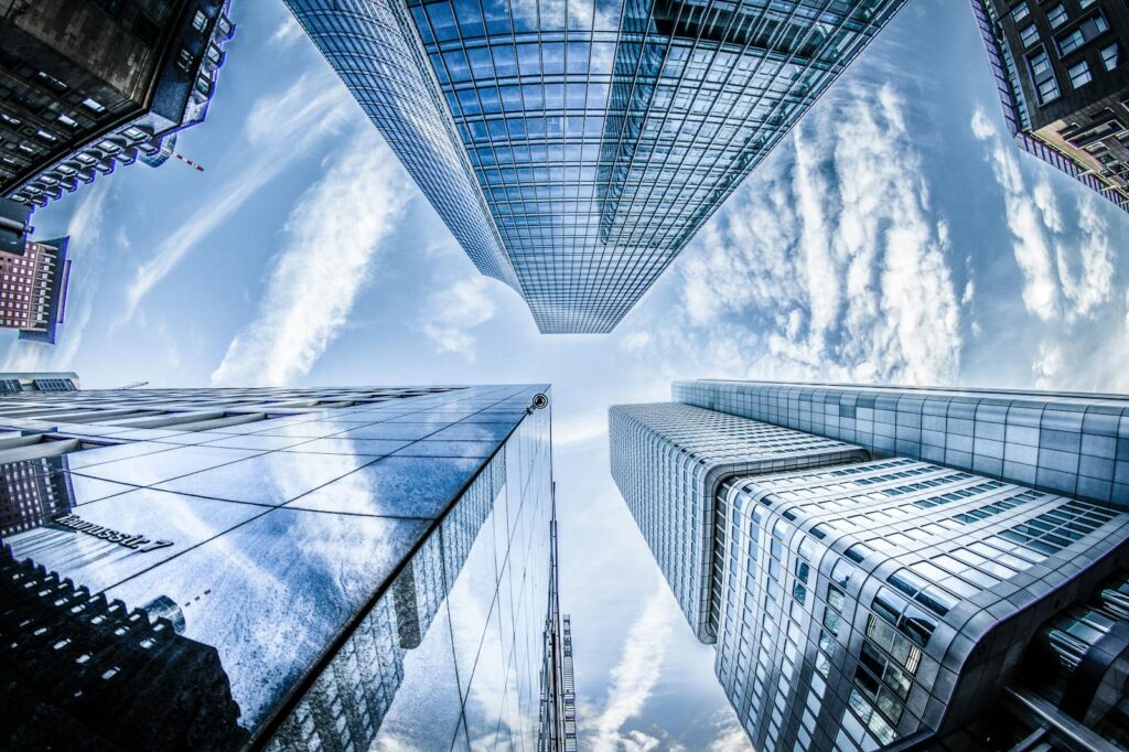 Low angle shot of modern skyscrapers in Frankfurt, showing reflections and sky.