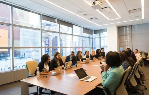 A diverse team of business professionals collaborating in a modern meeting room.