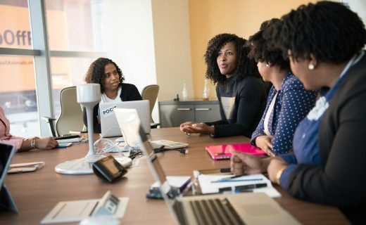 Diverse team of professionals engaging in a collaborative office meeting around a desk.