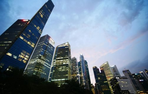 Low angle view of illuminated skyscrapers against a twilight sky, capturing urban architecture and city life.