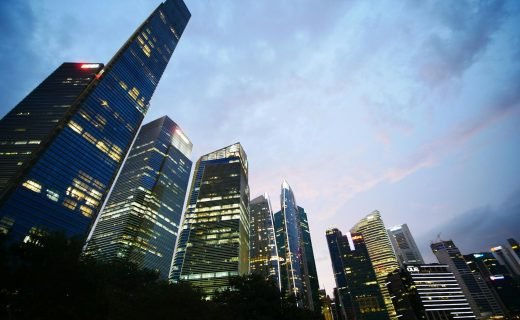 Low angle view of illuminated skyscrapers against a twilight sky, capturing urban architecture and city life.