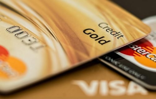 Stack of various branded credit cards focusing on gold card showing finance and cashless concept.