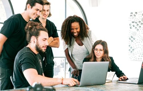 Dynamic team of young adults collaborating on project in bright modern office environment.