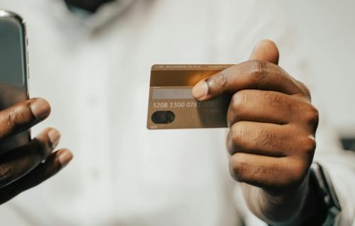 Person using a smartphone and credit card for online shopping or payment.