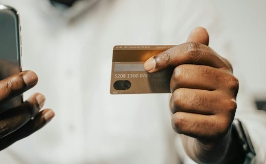 Person using a smartphone and credit card for online shopping or payment.