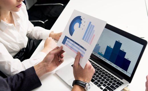 Business professionals discussing data charts and graphs in a modern office setting.