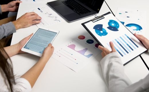 Team analyzing financial charts and digital reports during a business meeting.