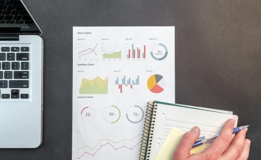 Overhead view of a business desk with charts and a laptop, ideal for data analysis concepts.