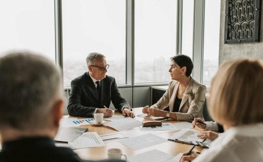 Business professionals engaged in a strategic meeting in a modern office setting with natural light.
