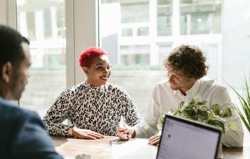 Casual business meeting with diverse professionals discussing a project.
