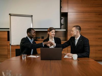 Diverse business team having a successful meeting and agreement, shaking hands across the table.