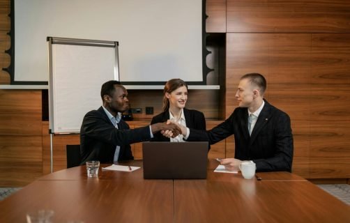 Diverse business team having a successful meeting and agreement, shaking hands across the table.