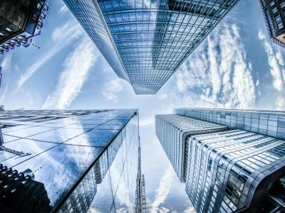 Low angle shot of modern skyscrapers in Frankfurt, showing reflections and sky.