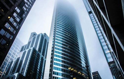 Dramatic view of modern skyscrapers shrouded in fog in an urban cityscape.