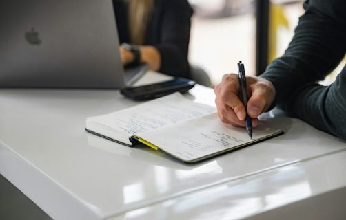 person writing on white paper