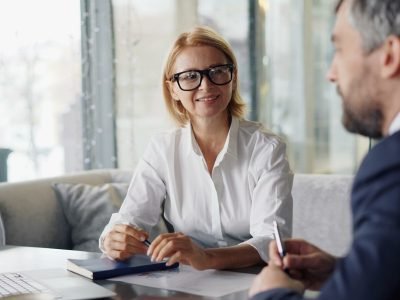 a man and woman sitting at a table with a laptop