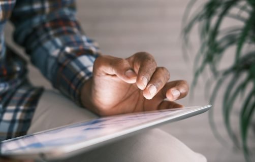 person in blue white and red plaid long sleeve shirt reading book