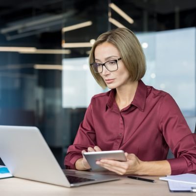 Confident,Businesswoman,With,Eyeglasses,Working,Diligently,On,A,Laptop,And