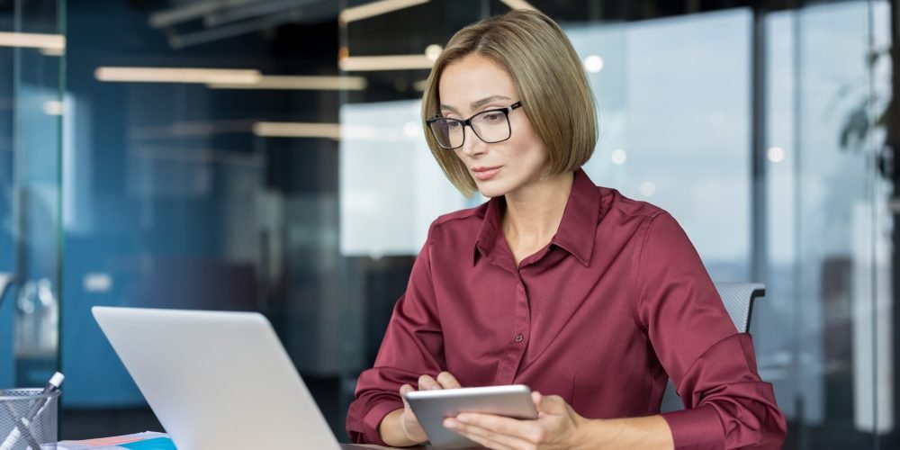 Confident,Businesswoman,With,Eyeglasses,Working,Diligently,On,A,Laptop,And