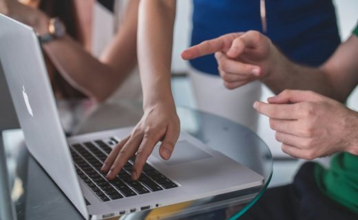 person touching and pointing MacBook Pro
