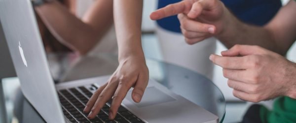 person touching and pointing MacBook Pro