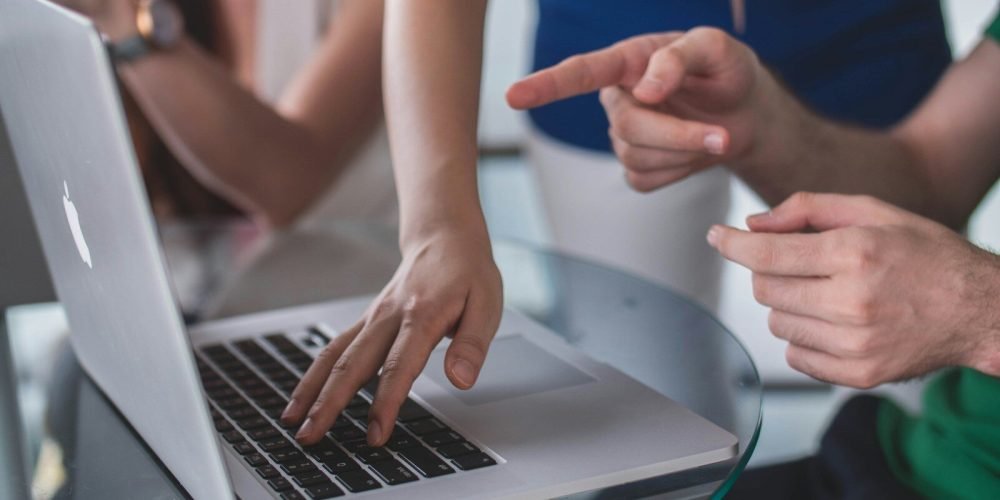person touching and pointing MacBook Pro